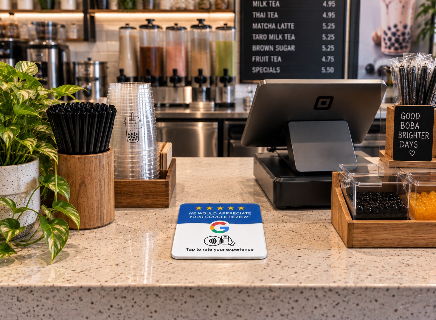 Google review plaque on a bubble tea shop counter next to the card payment reader